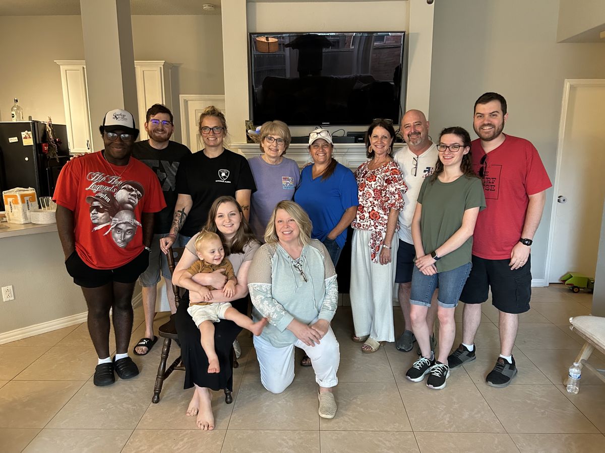 A Home Group standing together for a photo in a living room, adults and a toddler